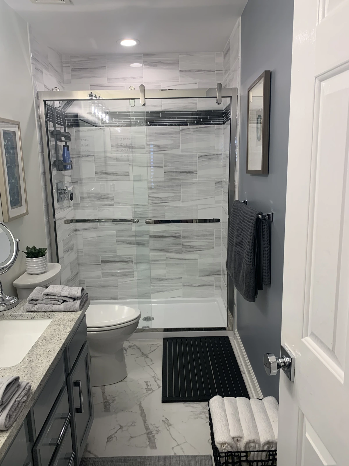 Full bathroom with marble-look tile shower