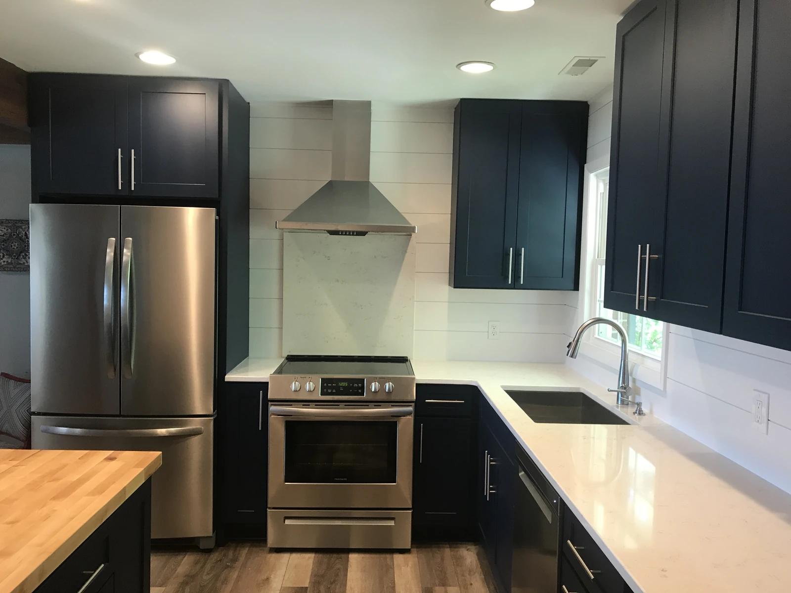 Navy cabinet kitchen with shiplap and stainless appliances