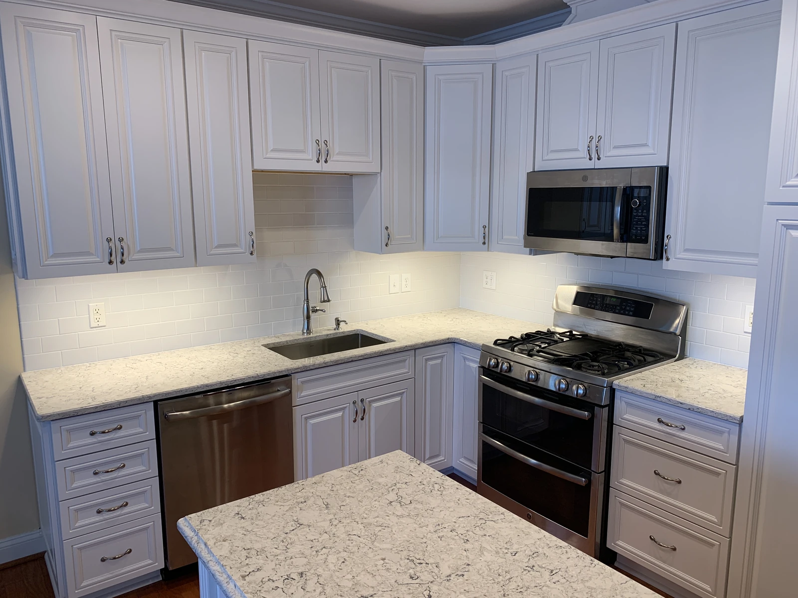 White kitchen with island and granite
