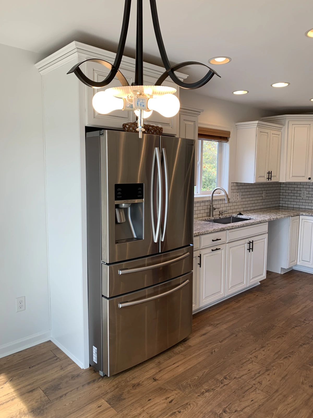 White kitchen with stainless fridge