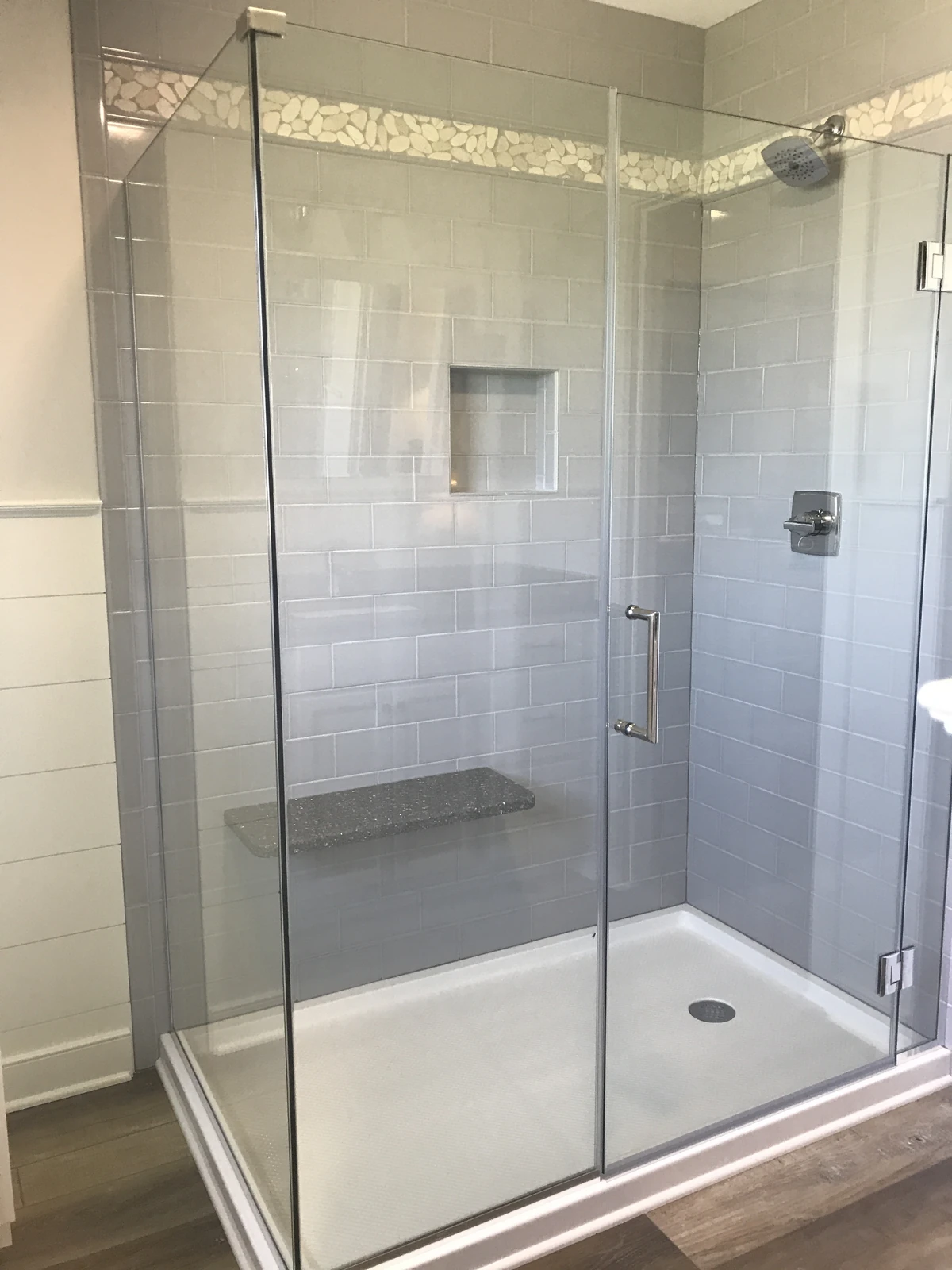 Gray subway tile shower with bench