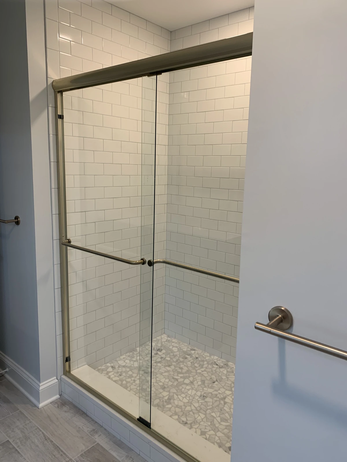 White subway tile shower with pebble floor